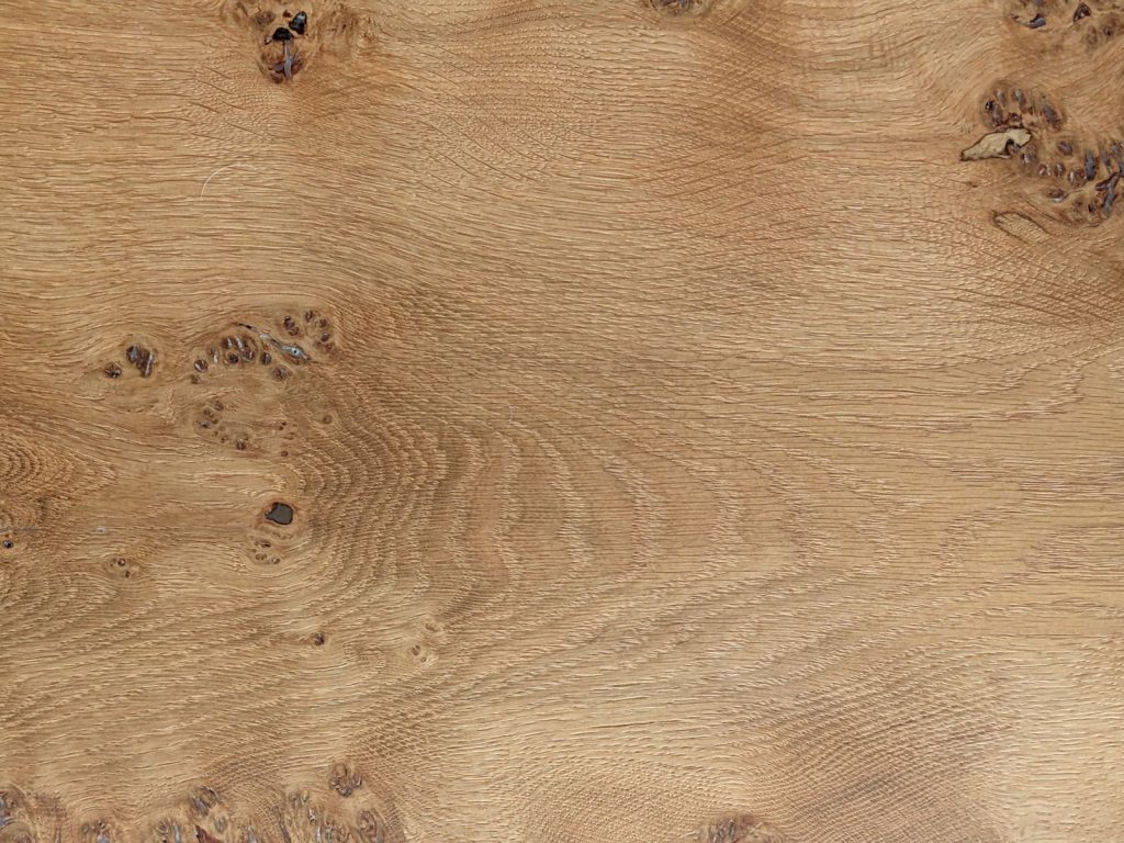 Gros plan sur le veinage et les nœuds d'un plateau en bois massif clair